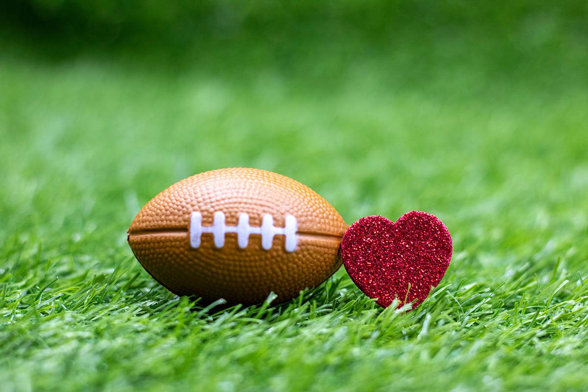 A football and a heart on a turf field.