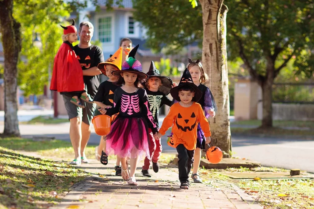 Group of kids in costumes heading out for spook-tacular and safe Halloween