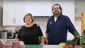 Giancarlo and Rosalia standing behind the counter with various items for a BBQ Feast